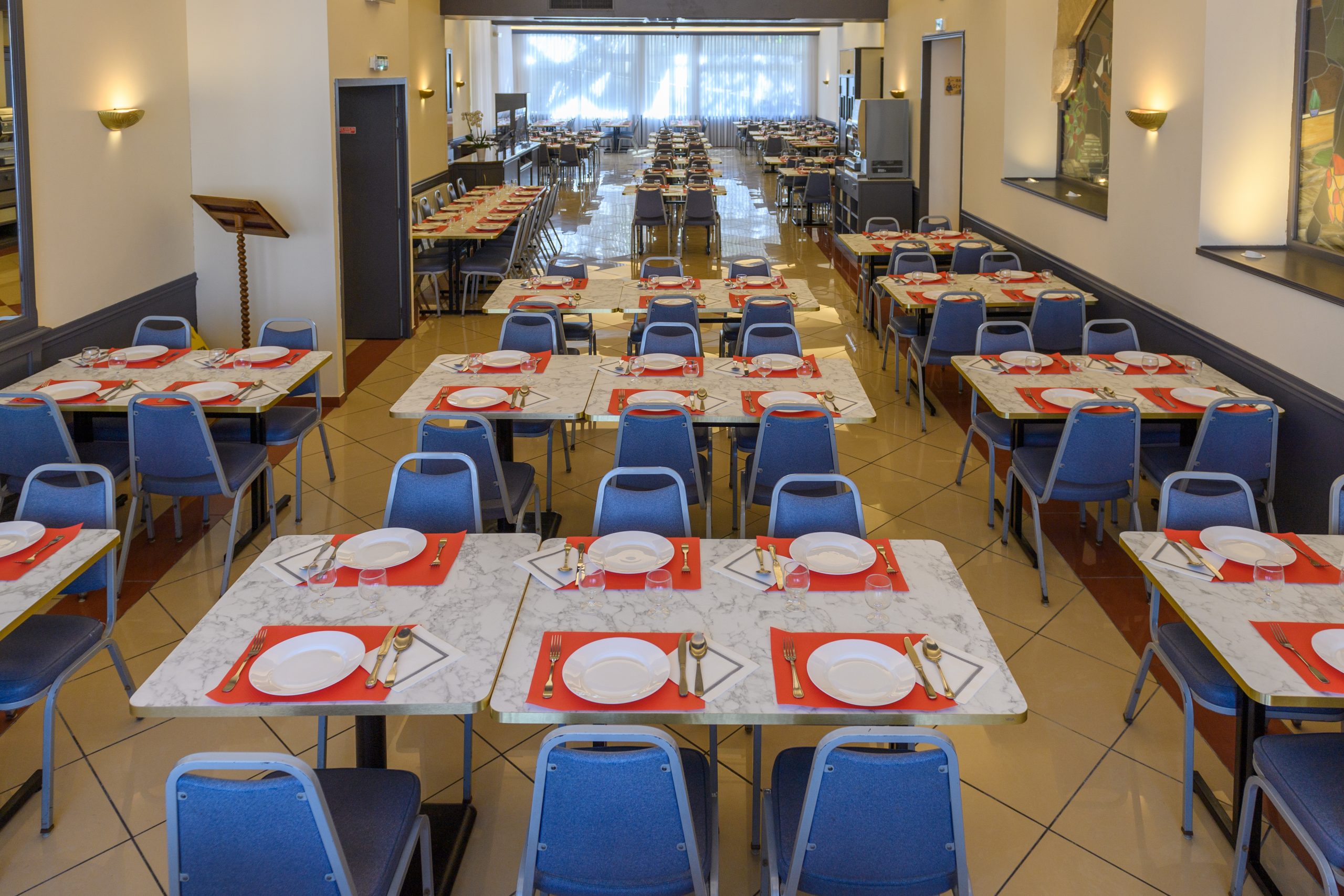 Tables d'une grande  salle de  restaurant de l'hôtel d'Espagne à Lourdes