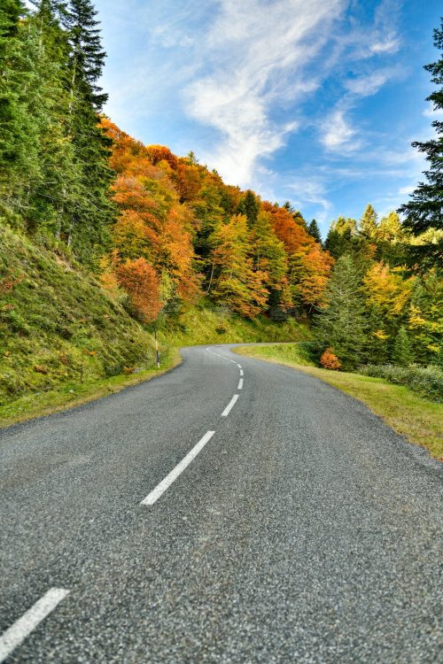 Couleurs d'automne, la route de montagne sinueuse vers un magnifique ciel bleu, Pyrénées, vallée d'Ossau