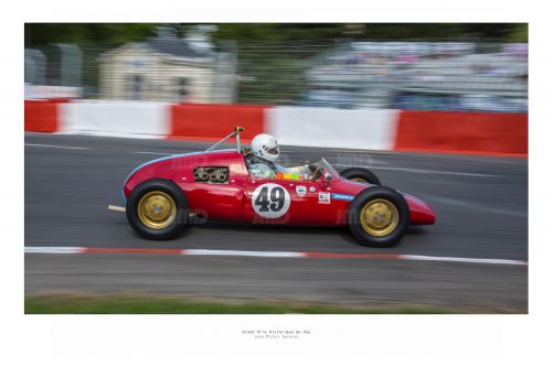 Voiture de course rouge en effet de filé  au virage de la gare lors du grand prix historique de Pau