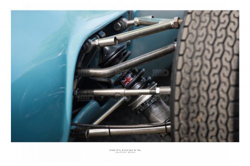 Vue  d'un bras articulé de suspension de véhicule de course de collection bleu dans son stand avant sa course au Grand Prix de Pau Historique avec sur l'amortisseur un drapeau Anglais
