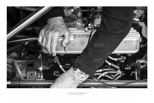 Un mécanicien répare un moteur  de véhicule de course de collection dans son stand avant sa course au Grand Prix de Pau Historique